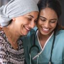 Healthcare worker embracing patient with head wrap