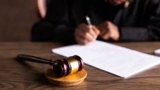 Gavel and hand signing paper