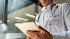 A doctor checking on a patient's record on a digital tablet