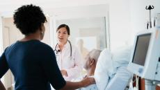 Doctor with hospital patient and another person standing