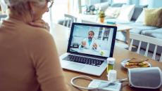 Cardiac patient talking to cardiologist on a telehealth call with monitor, medication and a sandwich on the table