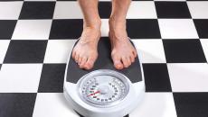 Feet on a scale on a black and white checkerboard floor
