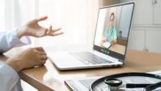 A female surgeon appears on a laptop with a stethoscope in foreground.