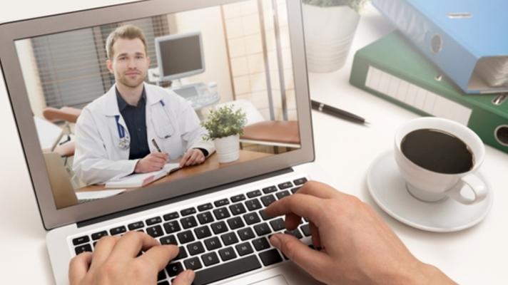 A doctor in a white coat on a computer screen