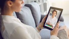 Person talking to healthcare provider on a tablet