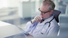 Doctor in a chair looking at a tablet