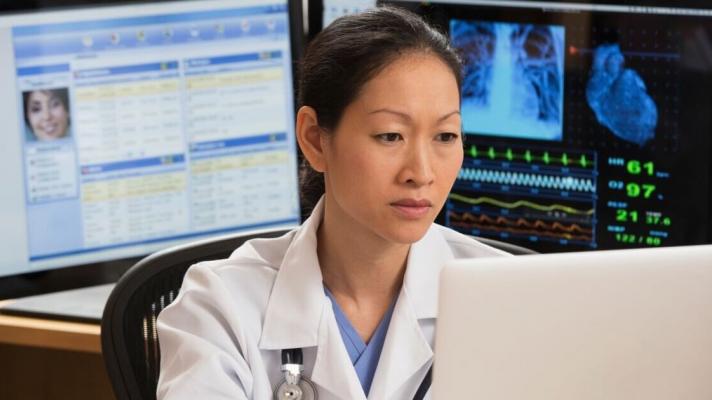 A doctor working on a laptop