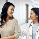 A doctor walking with a patient in a hospital corridor